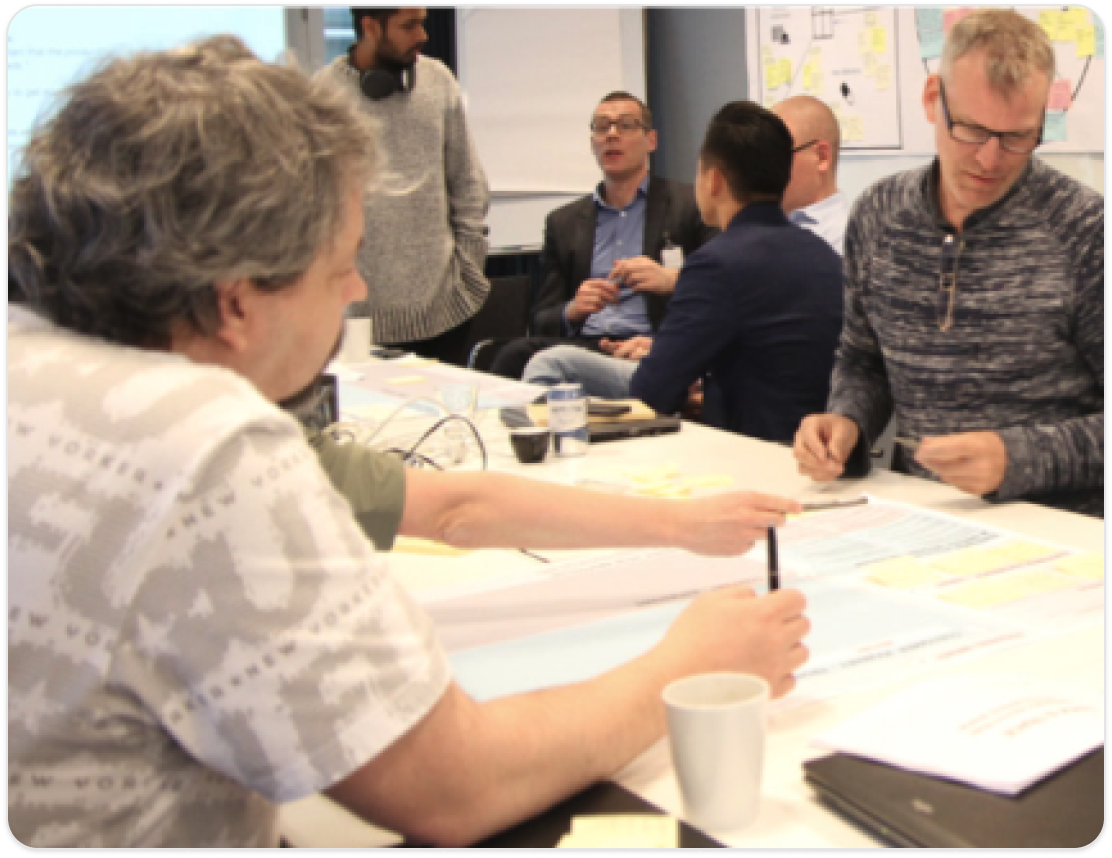 Stakeholders mapping user journeys with sticky notes